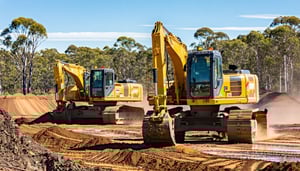 Two forty tonne excavators working hard in the Australian outback on a civil project